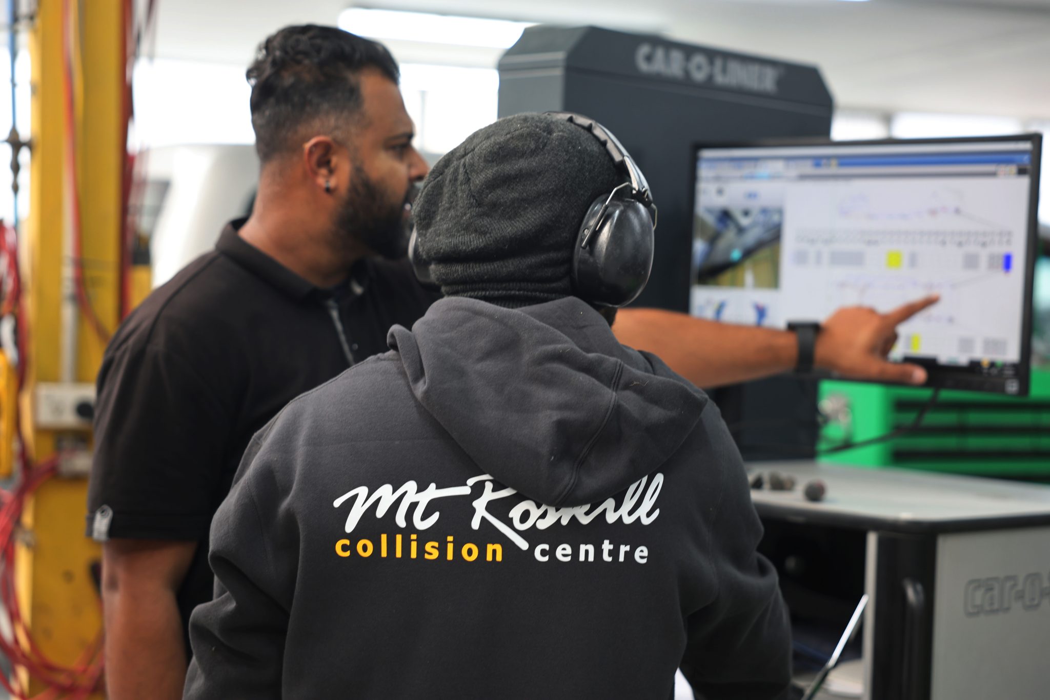 2 mechanics looking at computer screesn