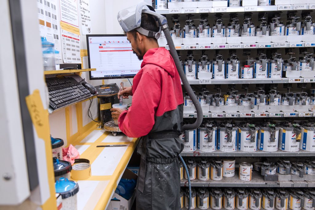 mechanic preps paint for painting