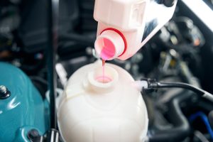 close-up-photo-of-mechanic-changing-antifreeze-flu-